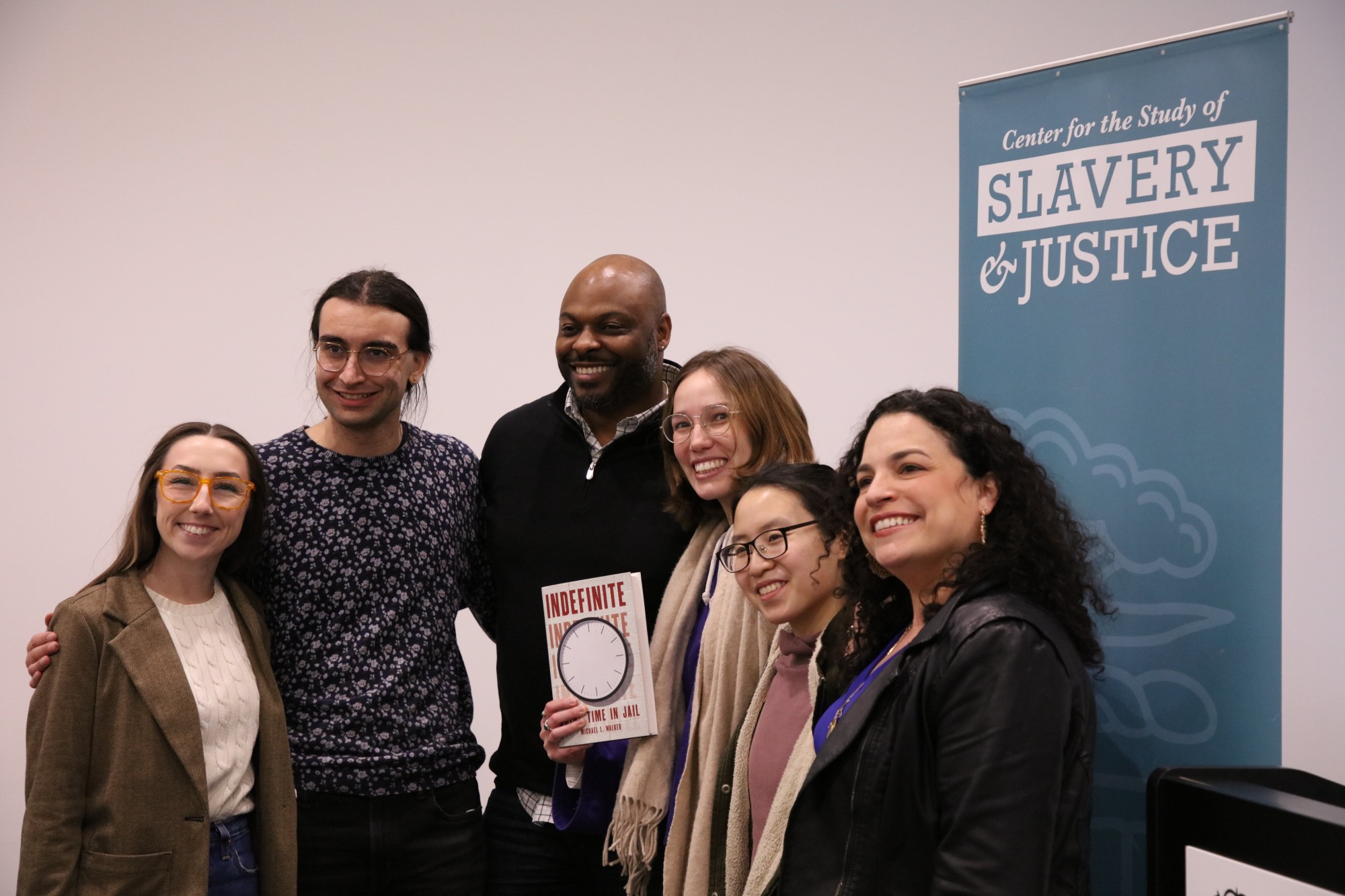 Attendees of Dr. Michael Walker's presentation of his book, “Indefinite: Doing Time in Jail” snap a photo.