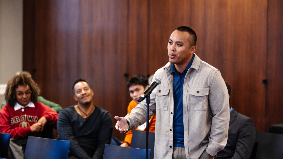 Gabriel Regalado speaks into a microphone at a Simmons Center event.