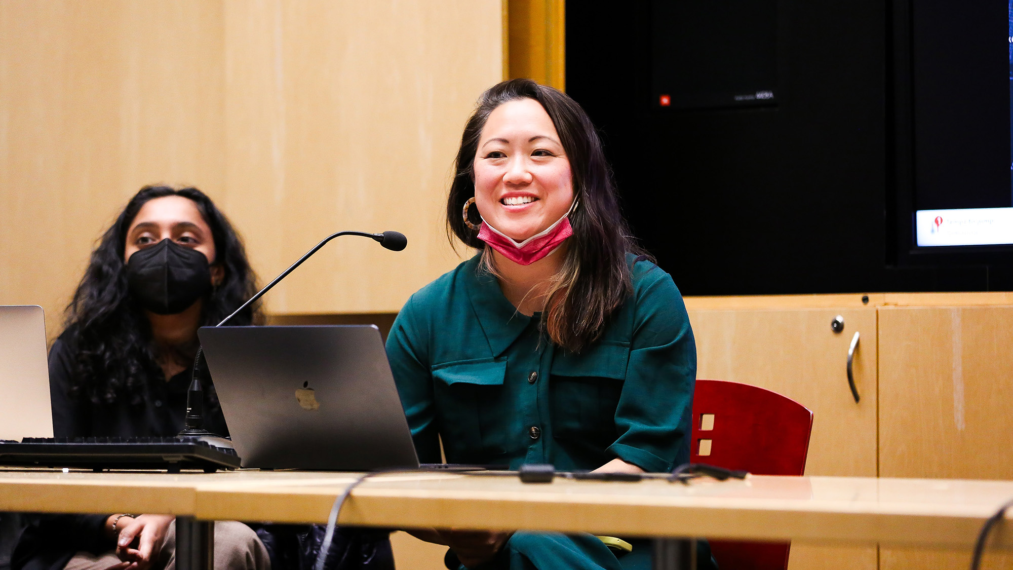 Elena Shih smiling as she's talking at a panel