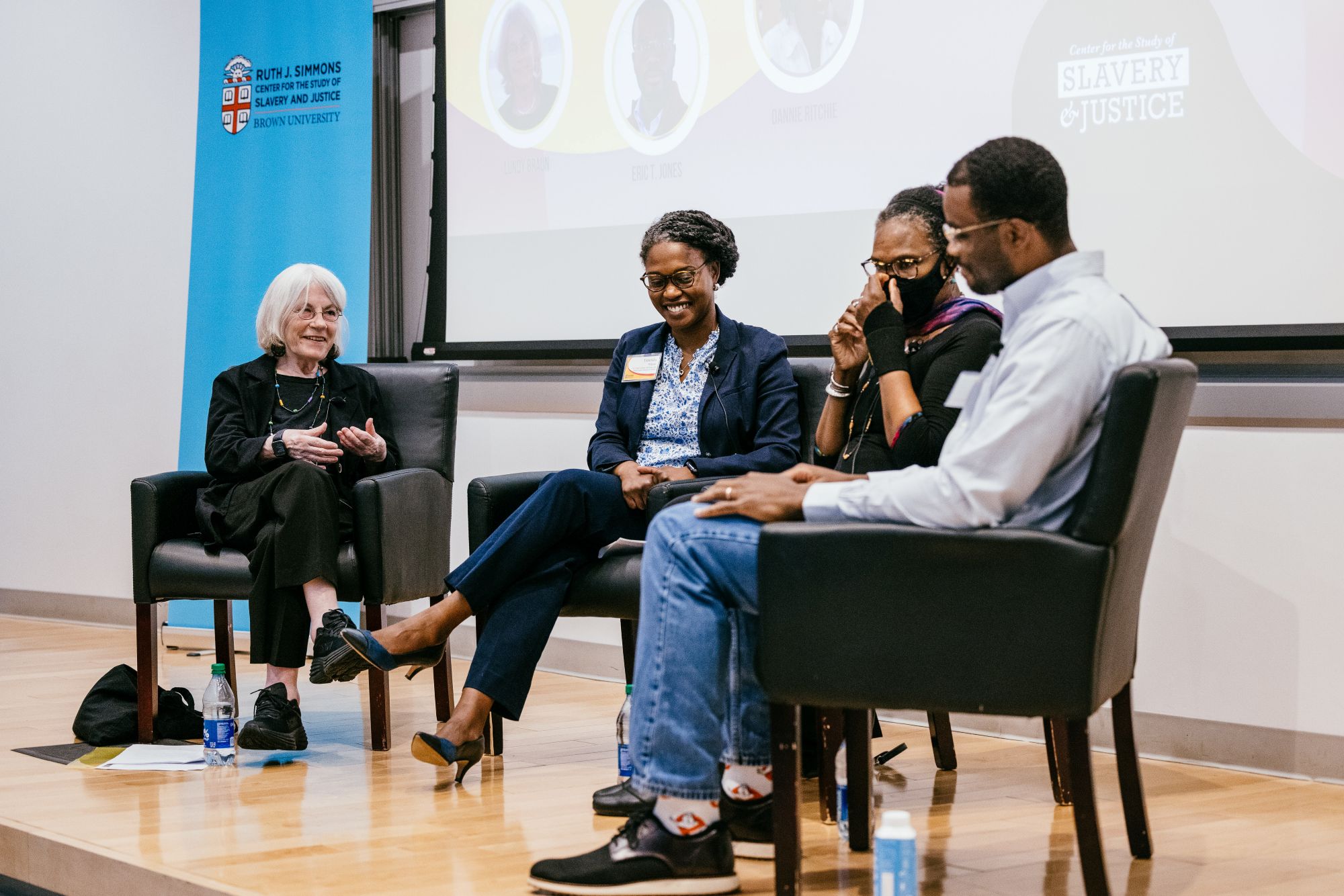 Four people seated for a panel discussion smiling at each other