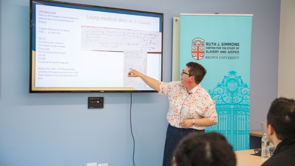 Traci Picard gestures to her presentation, sharing her archival research findings.