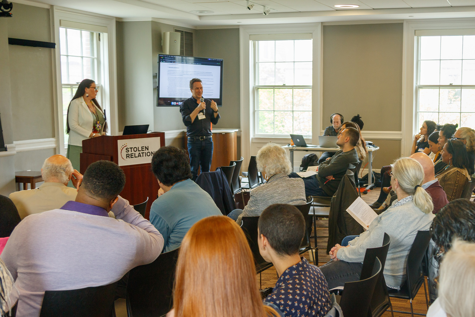 A professor addresses a group of people