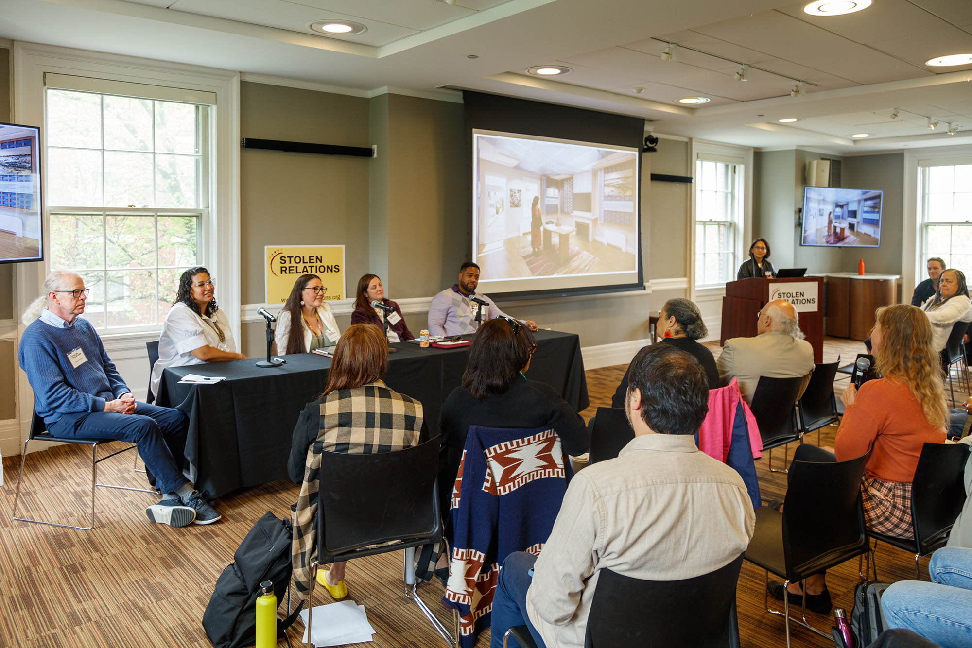 A group  of people at a panel talking to an audience