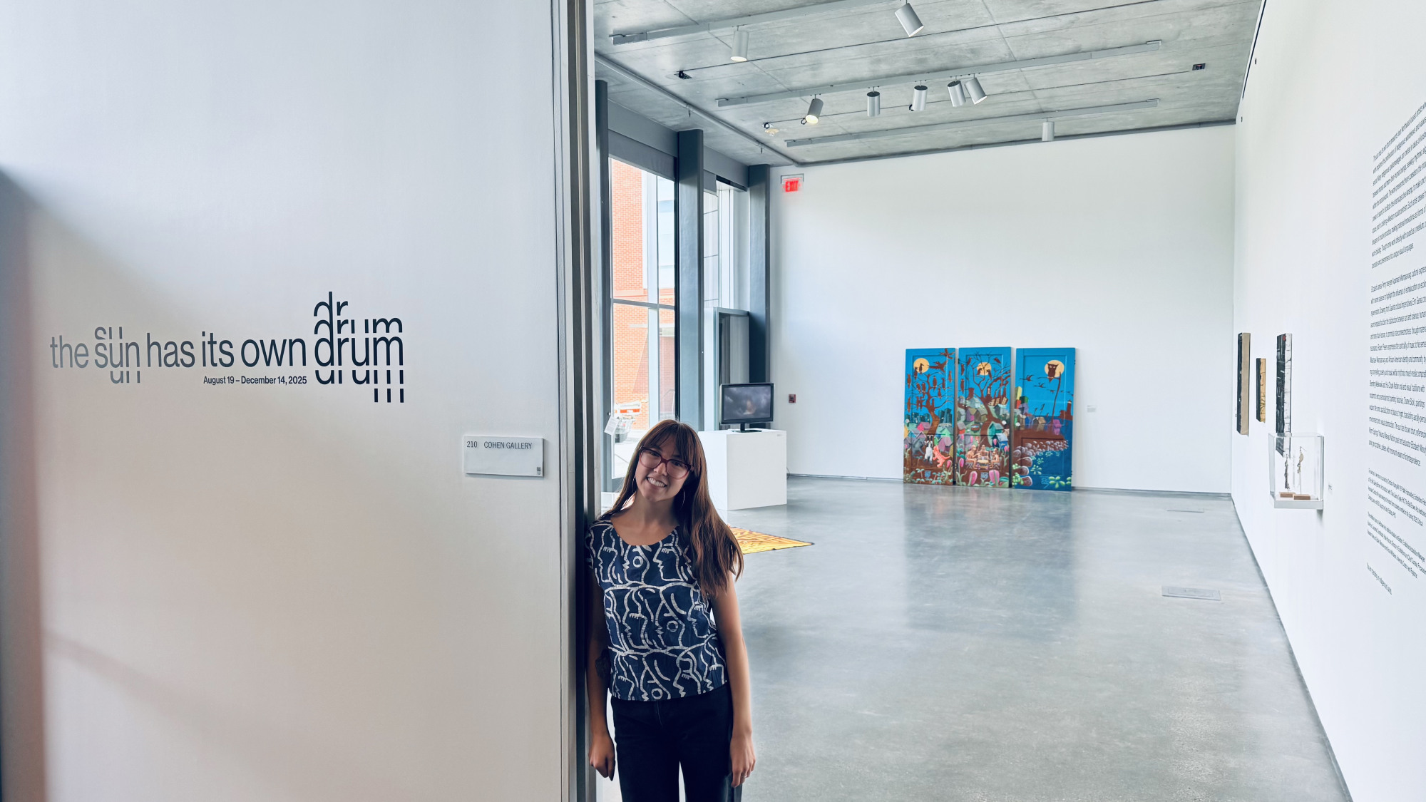 Christina Young smiling and standing in an art exhibition