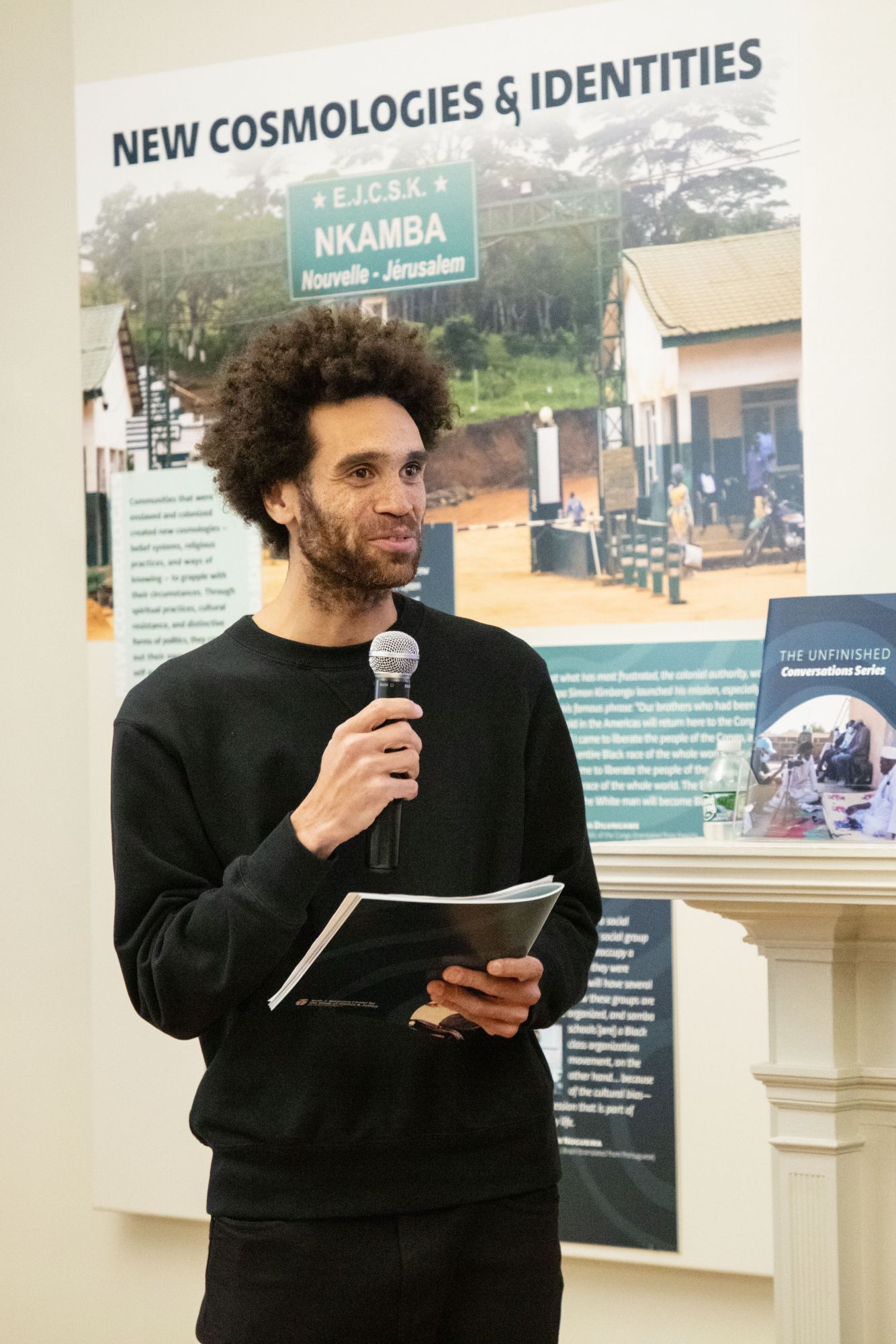 Man holding a microphone and speaking in the gallery