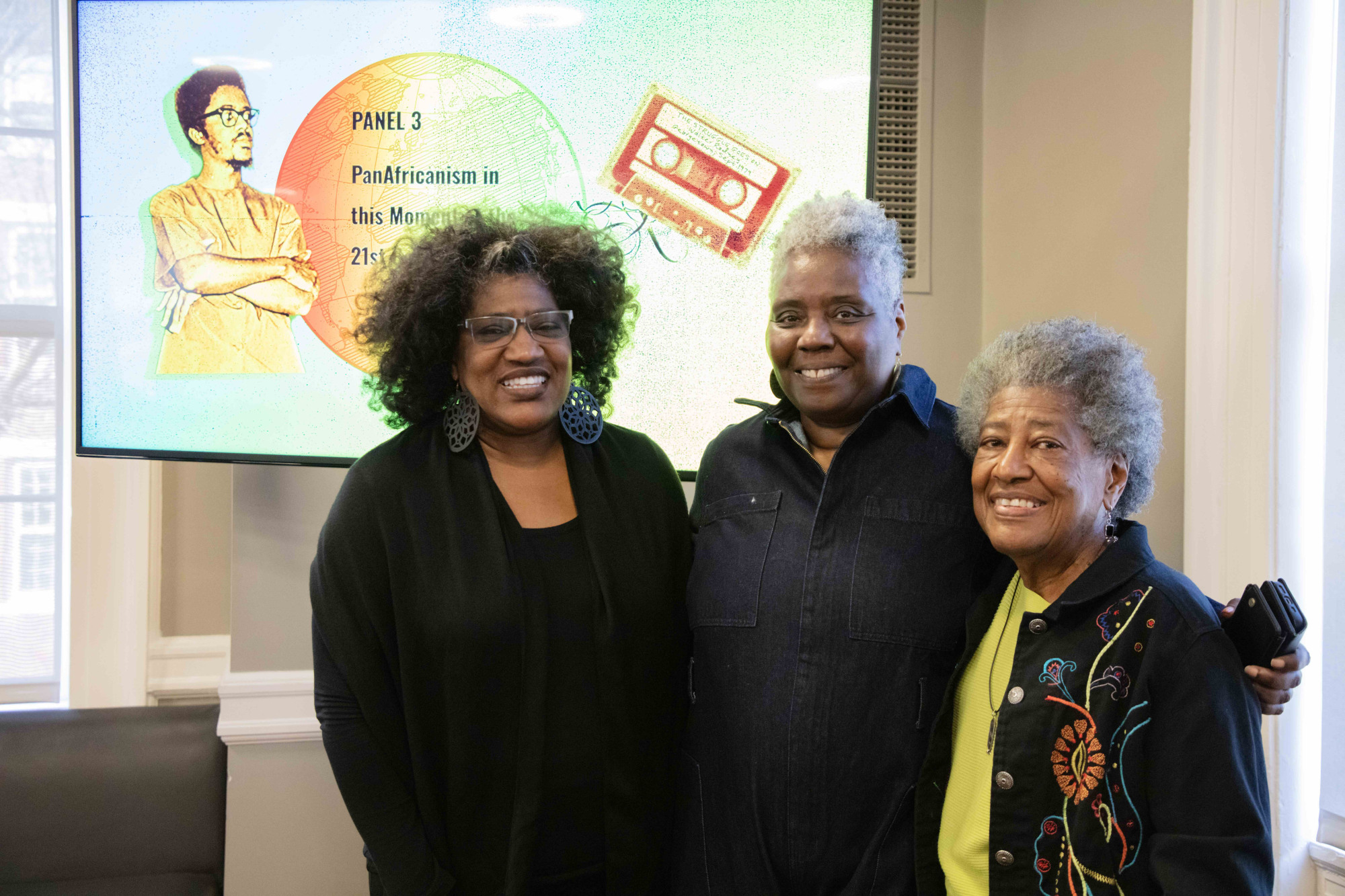 A group of people standing in front of a screen for the Walter Rodney Symposium.