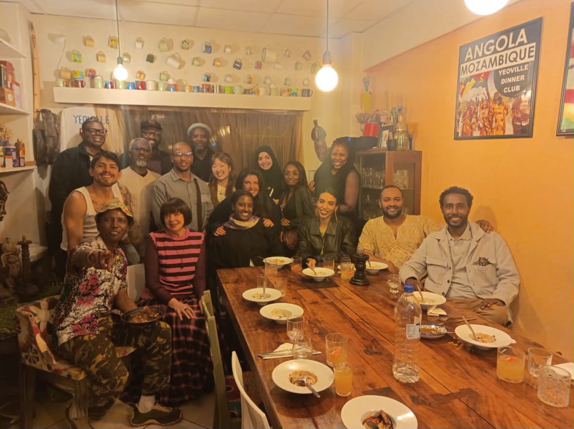 Fellows gathered in a room for a shared dinner.