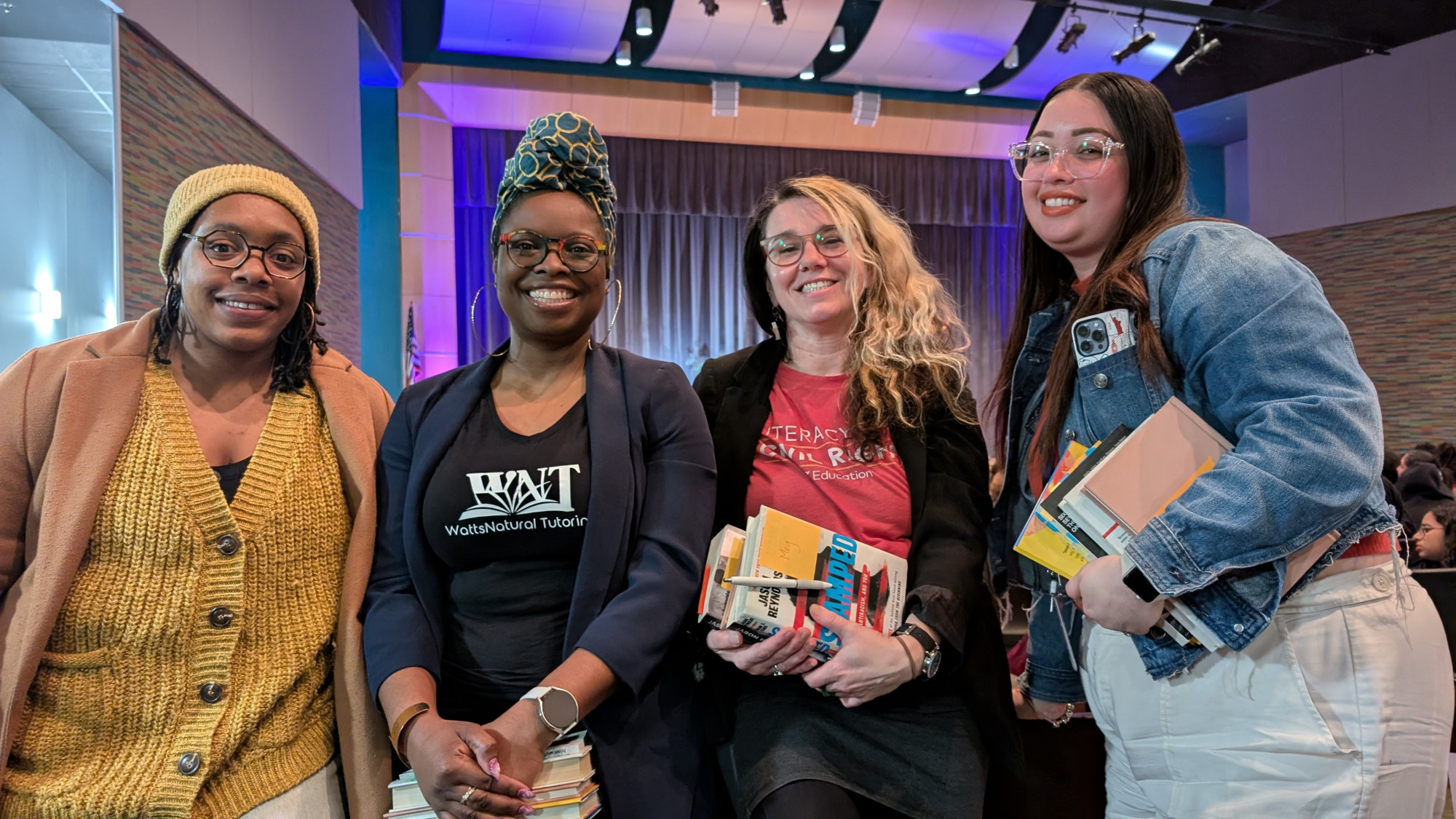 Group of women holding books and smiling.