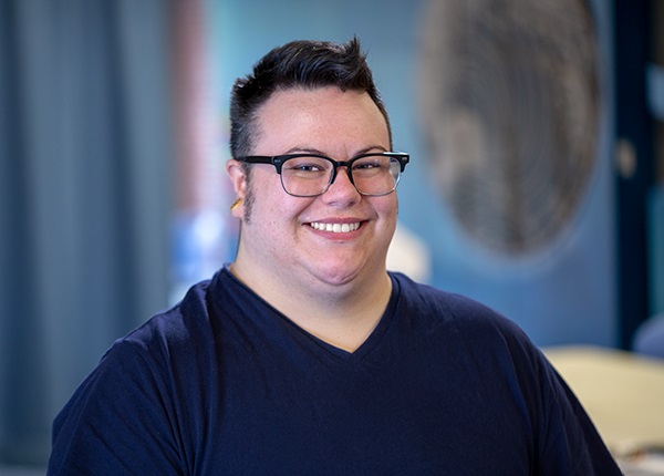 Headshot of Dan Everton seated in a blue sweater/