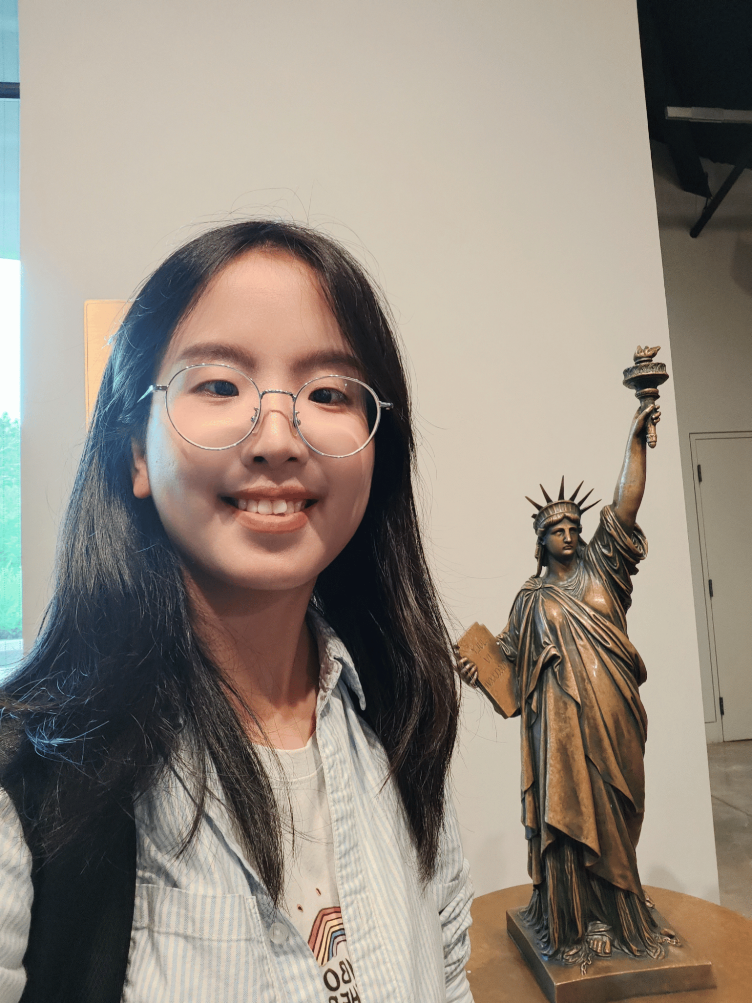 Girl standing in front of Statue of Liberty mini replica