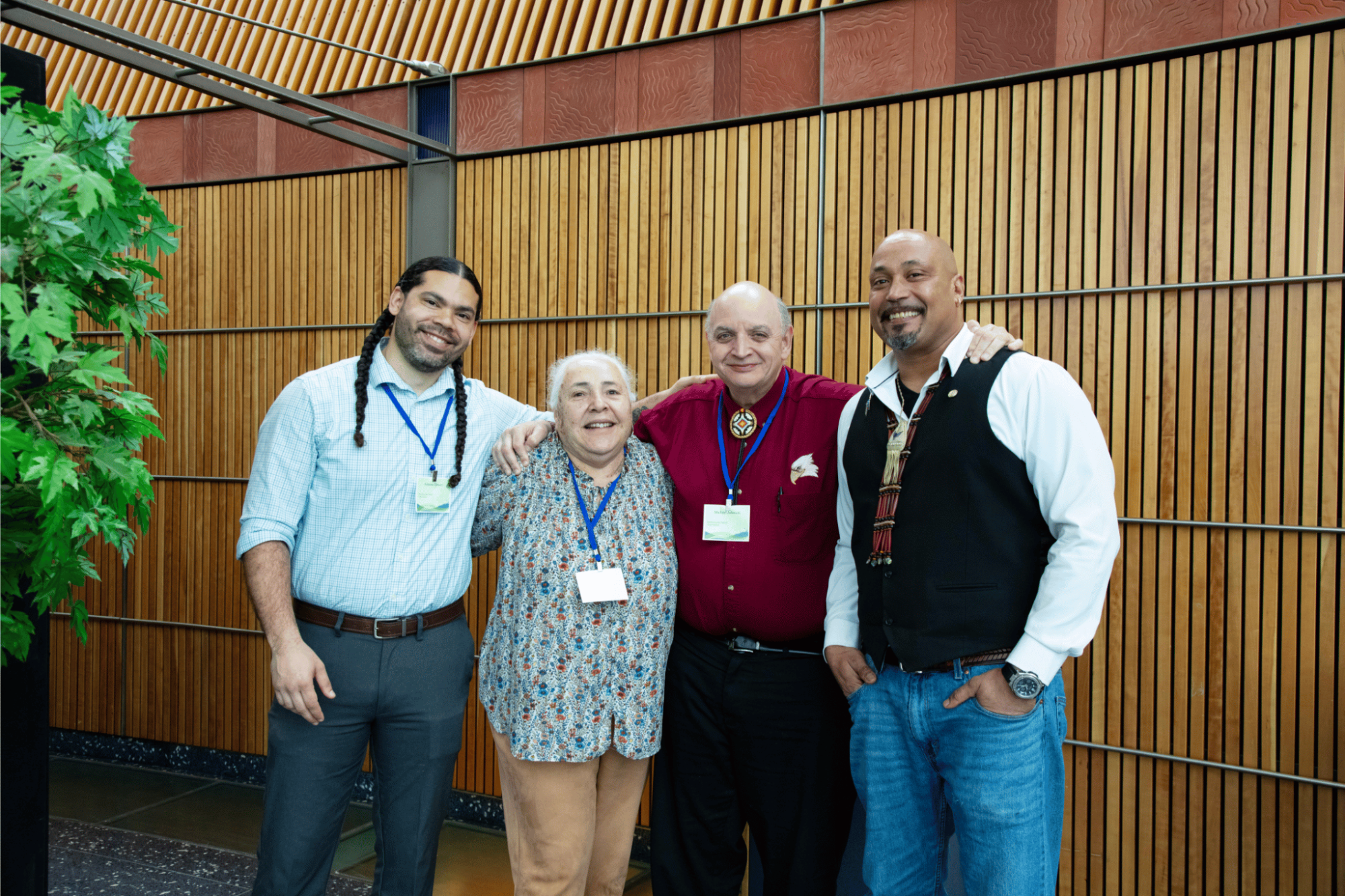 Group of four people standing arm in arm for a picture.