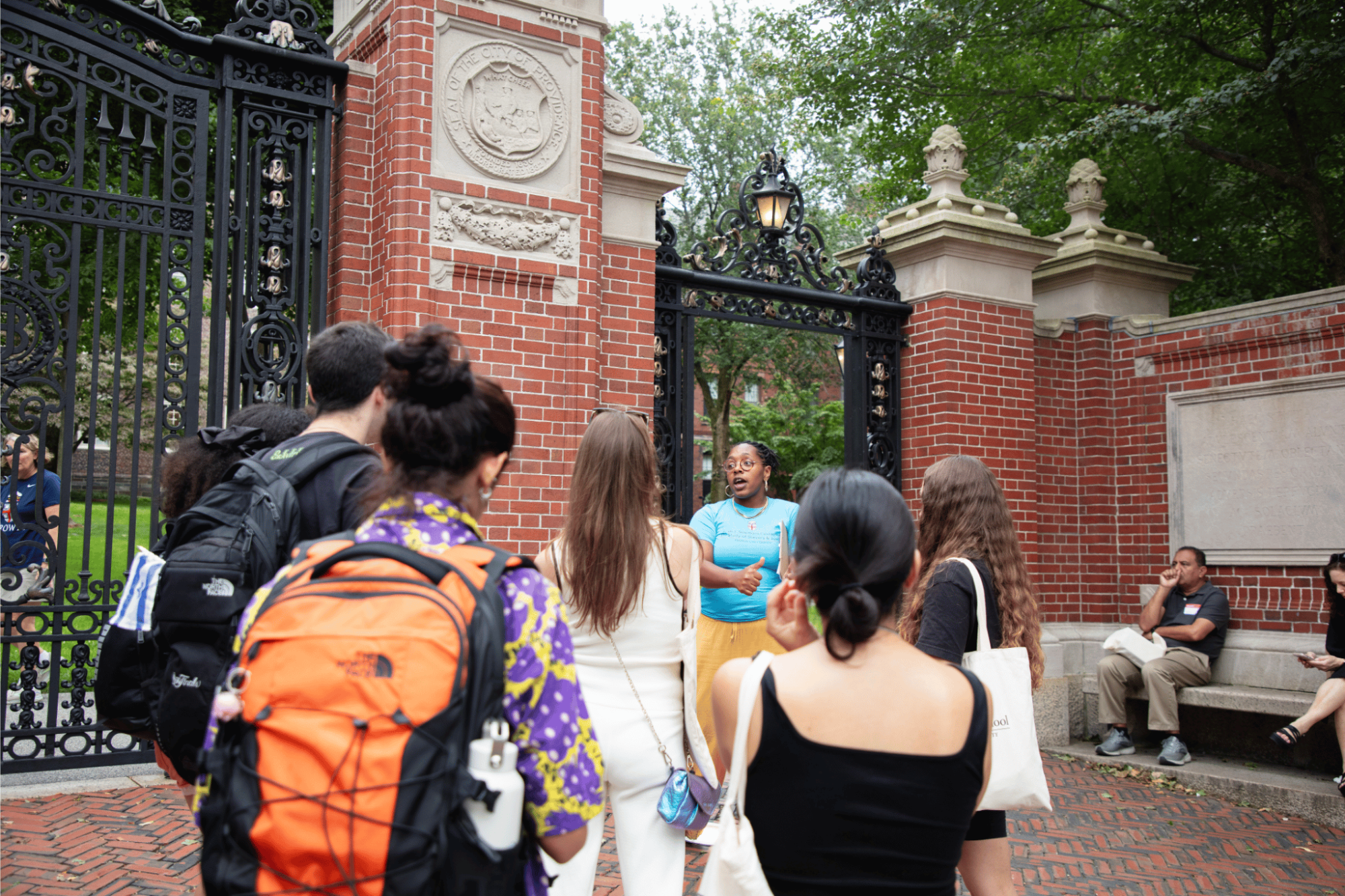 Group of people standing in a circle by the Van Wickle Gates.