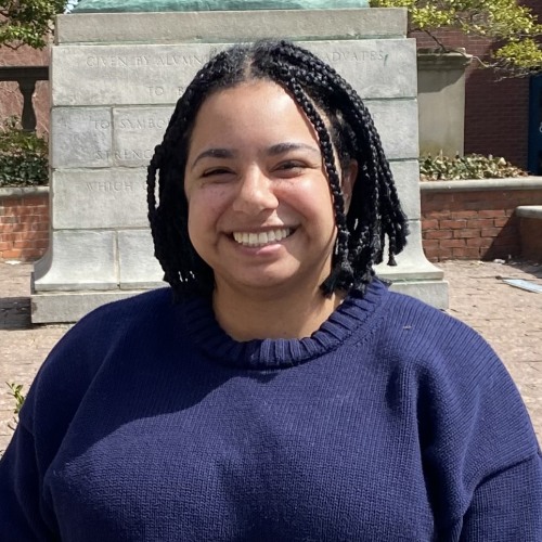 A woman with braids smiles at the camera