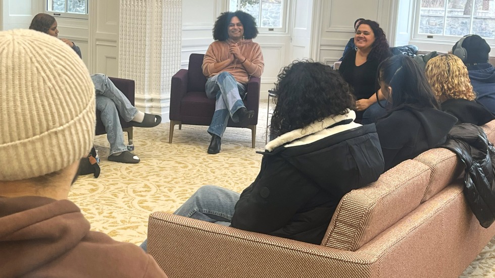 Students and speakers seated on couches discussing poetry