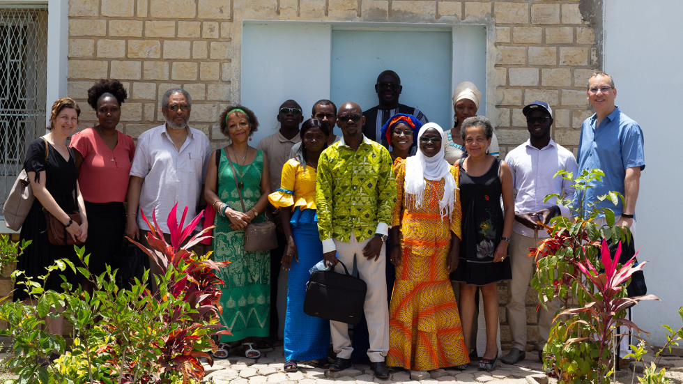 Large group of colorfully-dressed people standing outside a building