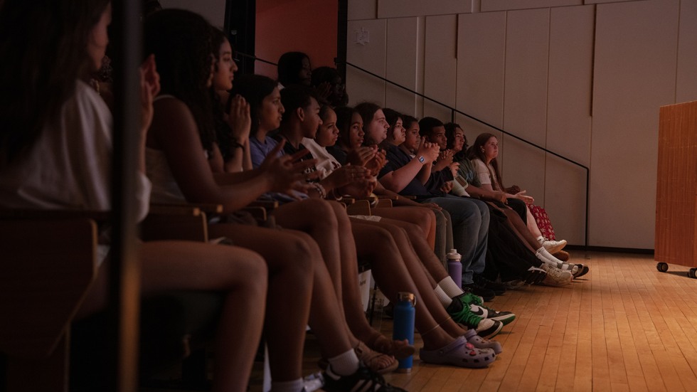 The audience of students applauds at the end of the presentation