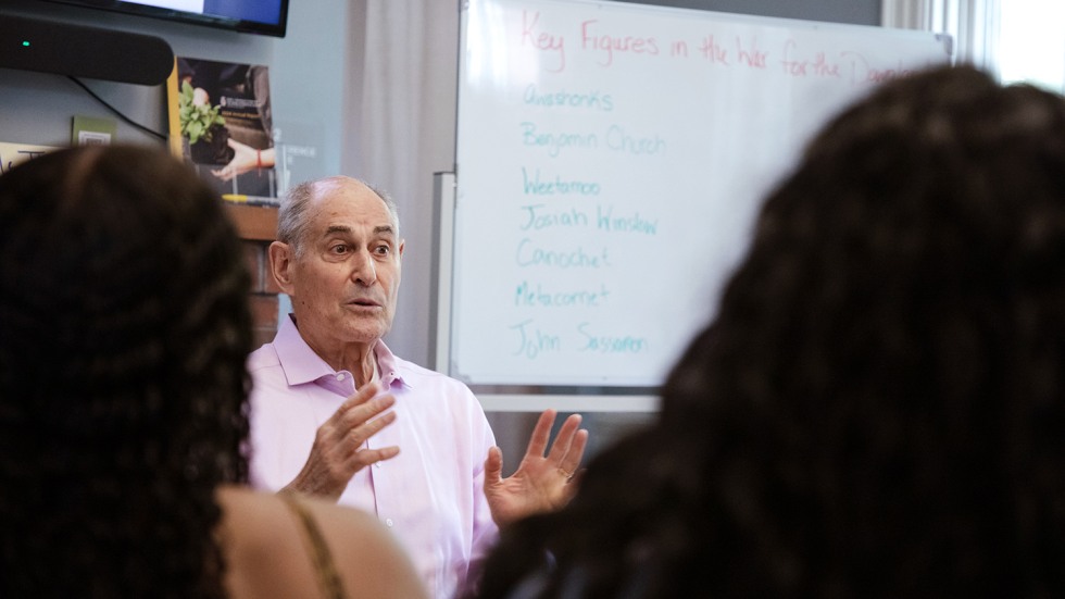 A man speaks while gesturing with both hands