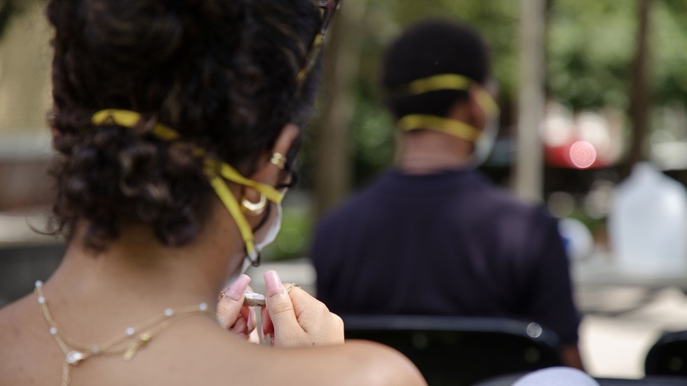 A student holds an examines a small piece of wampum