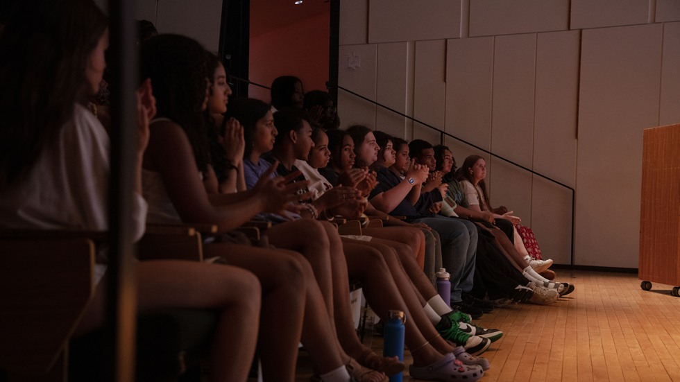 The audience of students applauds at the end of the presentation