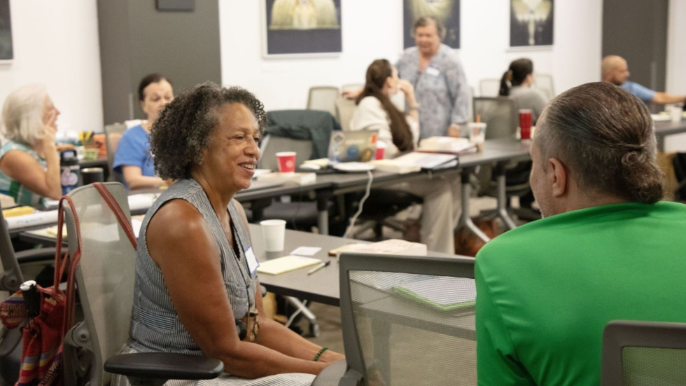 People sit talking in pairs around a classroom.